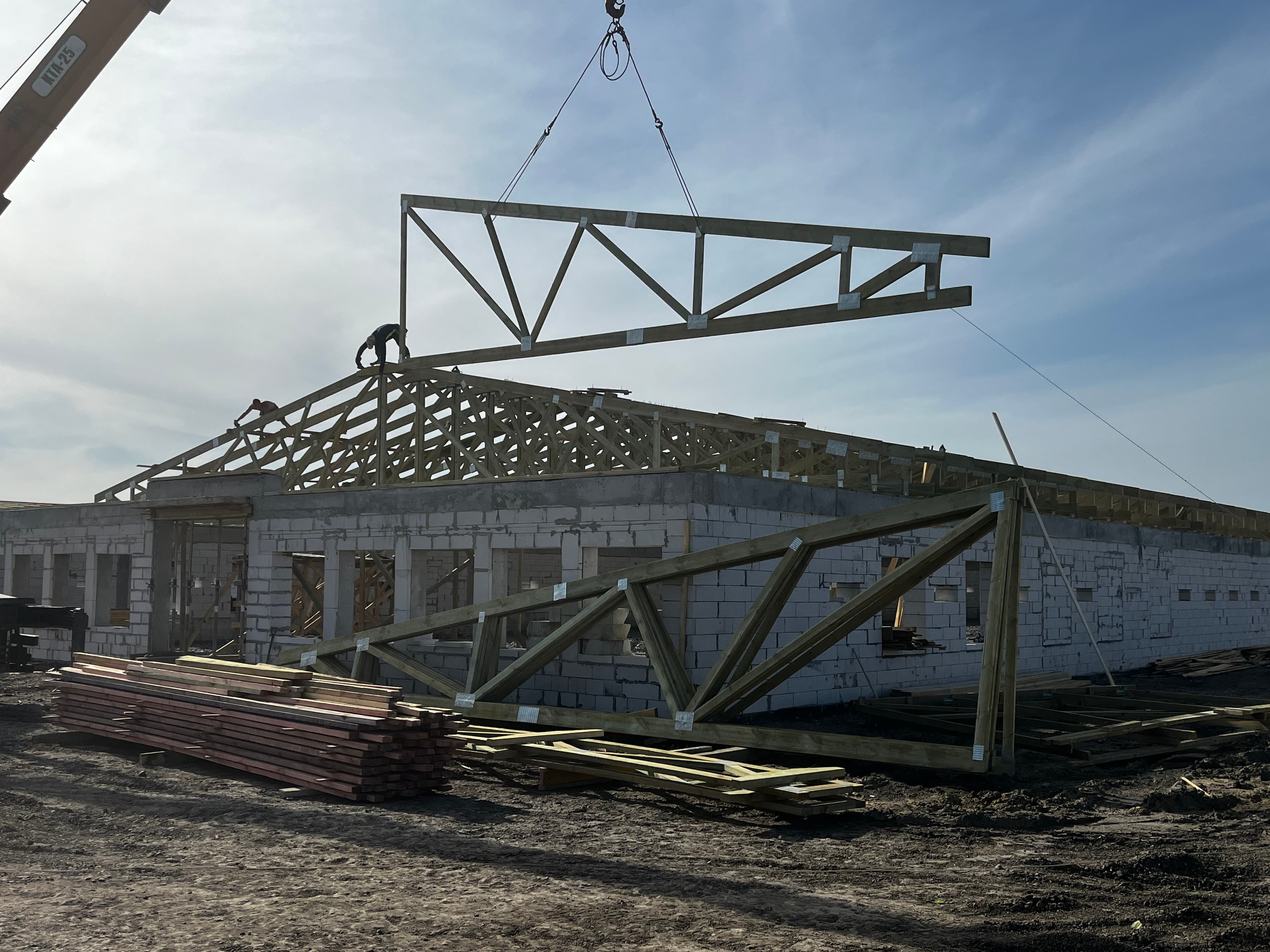 Монтаж ферми з металозубчатими пластинами краном на будівельному майданчику